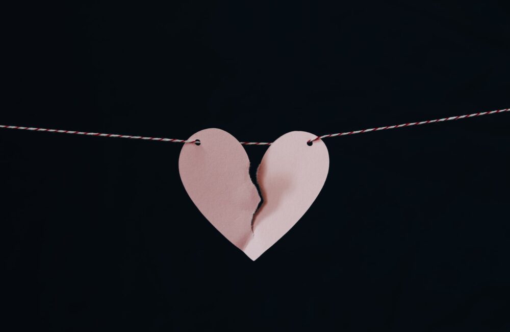 A close up of a broken paper heart hanging from a rope. Affair recovery in West Des Moines, IA can help you repair your relationship. Learn more about affair recovery counseling in West Des Moines, IA by contacting an infidelity counselor today! 50266