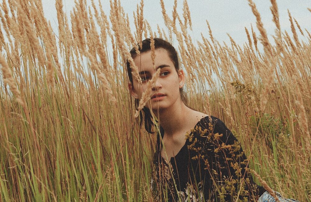 A young woman looks off through a wheat field. This could represent the isolation caused by anxiety. Treatment in Des Moines, IA can offer support with. Contact an anxiety therapist for more therapy about online anxiety therapy including methods on how to treat anxiety.