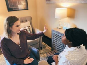 A trauma therapist sits across from a client as they wave their finger. This represents EMDR therapy in West Des Moines, IA. Contact a PTSD therapist for support with PTSD treatment in West Des Moines, IA. We also provide online trauma therapy in Iowa, so call today!