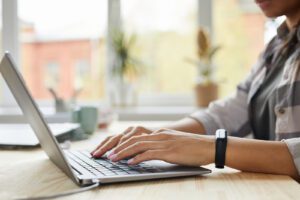 A close up of a man typing on a laptop. This could represent online therapy in Iowa. Contact an online therapist in Iowa for support with online therapy in West Des Moines, IA and other services. 