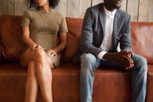 An couple sitting on a couch look away from one another. This could represent the tension that couples therapy and marriage counseling in West Des Moines, IA can offer. Learn more about marriage counseling from a couples therapist in West Des Moines, IA today.