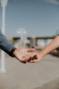 A close up of a couple holding hands on a pier. This could represent the bond online couples counseling in Iowa can cultivate. Contact an online marriage counselor in Iowa to learn more about online couples counseling and other services today! 50266 