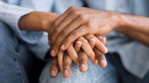 A close up of a couple holding each other's hands for Relationship and Intimacy Center. Contact a sexual health counselor in West Des Moines, IA to learn more about how sexual therapy online in Iowa can support you from home! 50266